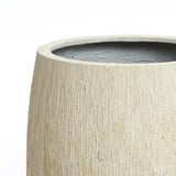 Close-up of a ribbed texture planter with a dark interior, set against a plain white background, showcasing its cylindrical beige design perfect for indoor outdoor settings.