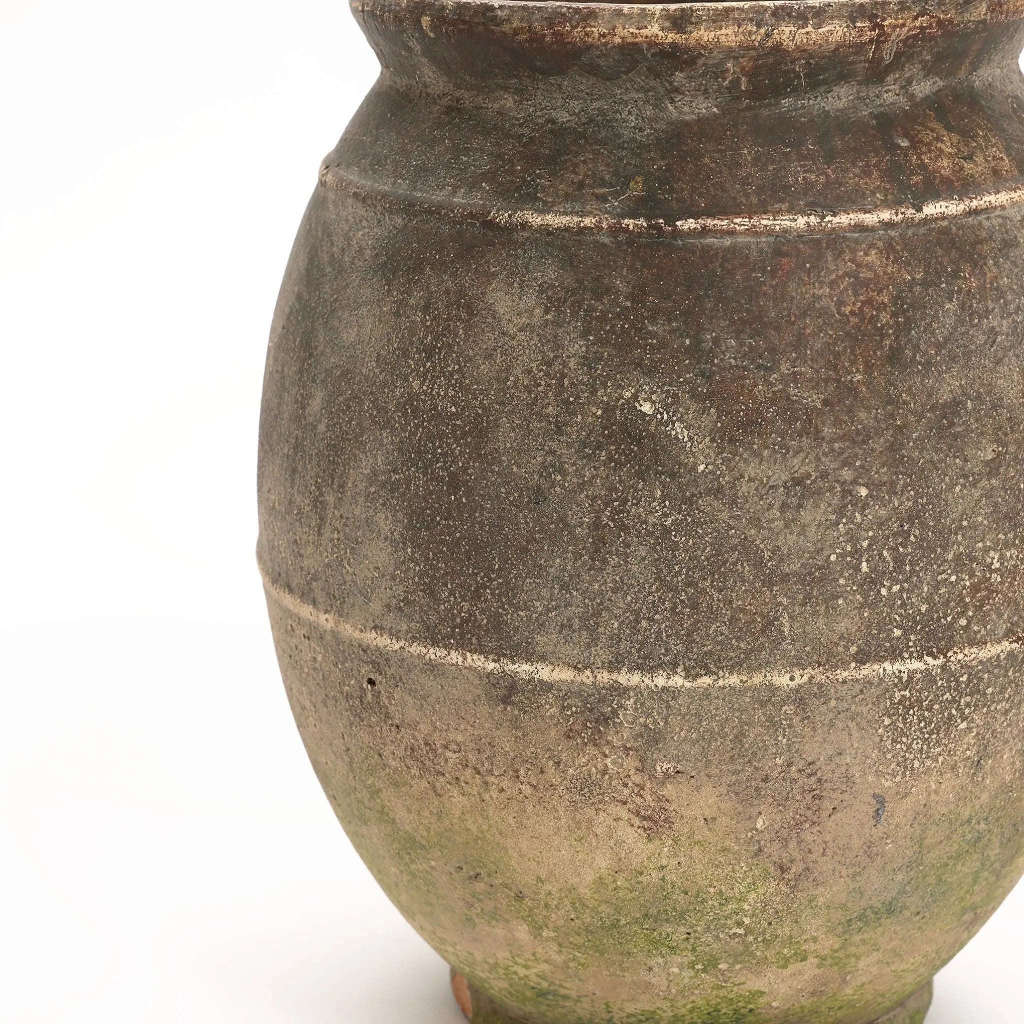 Close-up of an aged, large terracotta urn vase with a round body, a narrow top, and visible weathering and moss near the base. Perfect for both indoor and outdoor settings, its rustic charm adds character to any space.