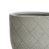 Close-up of the upper section of a round, textured planter with a woven pattern. The pot, crafted from MgO material, has a grayish hue and features a diamond-shaped design.