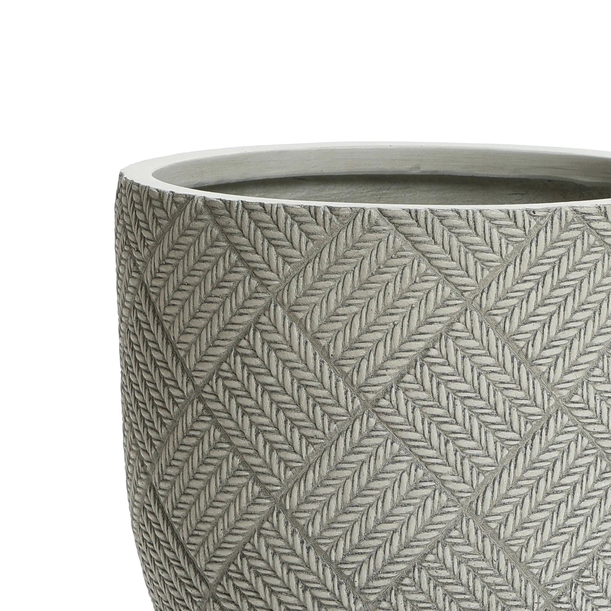 Close-up of the upper section of a round, textured planter with a woven pattern. The pot, crafted from MgO material, has a grayish hue and features a diamond-shaped design.
