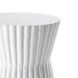 A close-up of the Speckled White Fluted Hourglass Outdoor Side Table reveals its rippled, speckled surface and vertical grooves. Crafted from durable MgO, the sleek design features a smooth tabletop that contrasts artistically with its cascading sides.