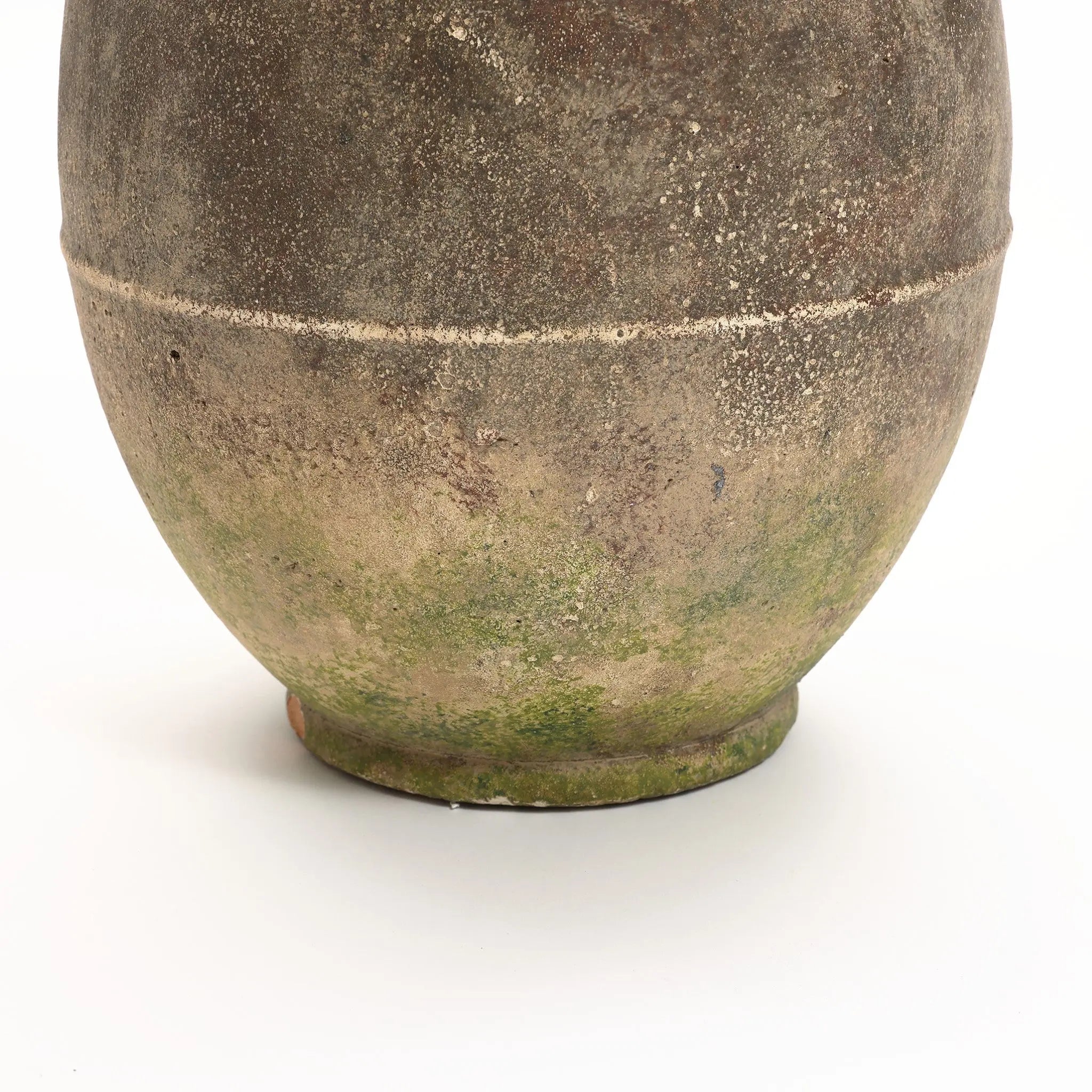 A close-up of a textured, rustic ginger root-inspired ceramic pot with a round base, showing mossy green and earthy brown tones against a plain white background. Perfect for both indoor and outdoor settings, this piece exudes timeless charm.