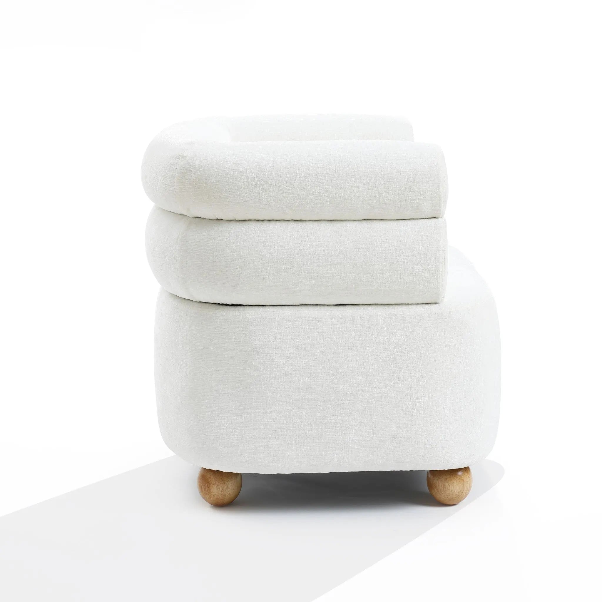 A side view of the Tia ivory barrel accent chair by LuxenHome, featuring a sleek, minimalist design with rounded cushions, a double bolster backrest for comfort, and wooden ball legs against a plain white background.