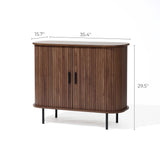 The Aria 2-door tambour accent cabinet by LuxenHome features a dark oak finish and black handles. With dimensions of 15.7 depth, 35.4 width, and 29.5 height, it stands on four black legs offering a sleek storage solution for any room.
