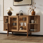 A cozy, well-lit room with wooden flooring features the LuxenHome Miko sideboard server cabinet with solid wood legs. Open shelves display pottery and dishes, while a table lamp and dried flowers in a vase sit on top. A framed abstract painting hangs above completing the mid-century modernist look.