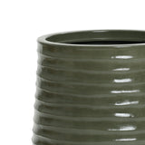 A close-up of a green, glossy, ribbed ceramic vase with a cylindrical shape and drainage hole, perfect for both indoor and outdoor environments, set against a plain white background.