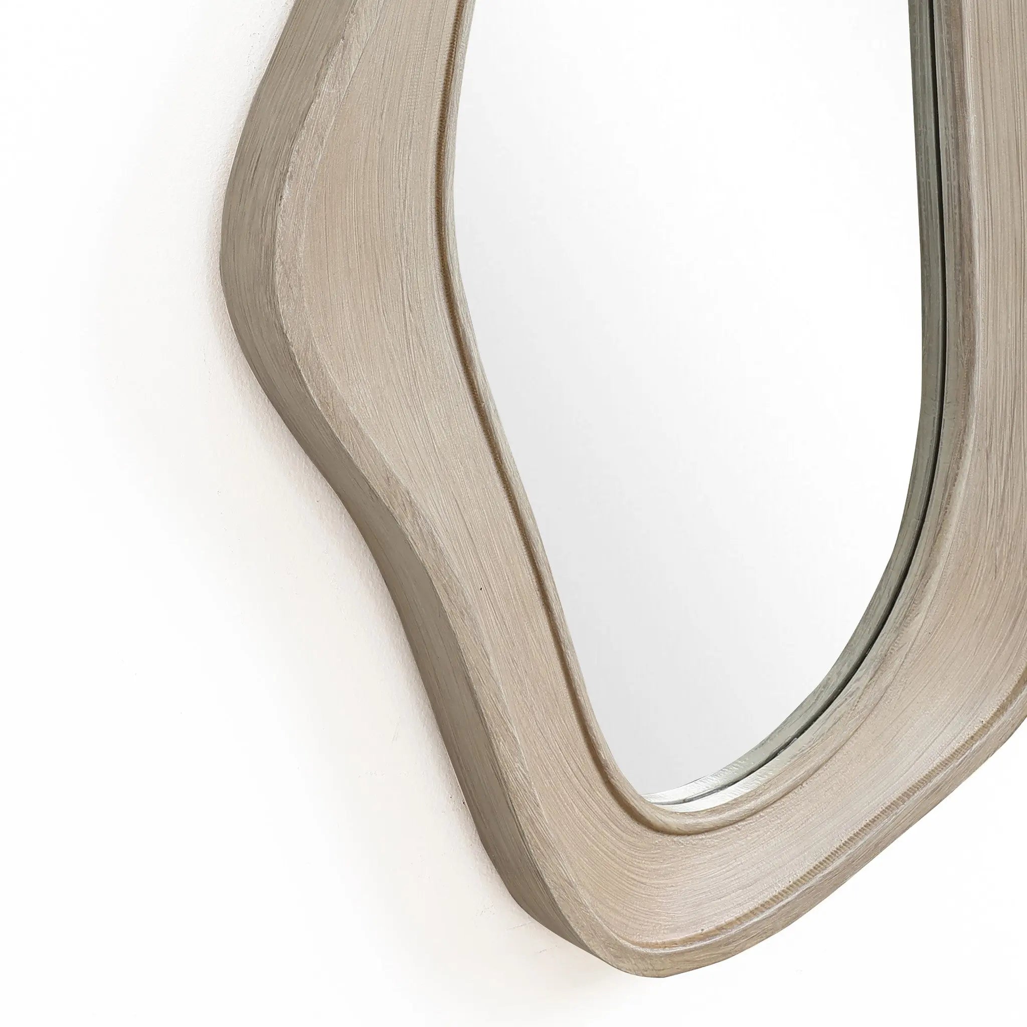 This modern home decor piece features an oval, irregularly shaped wall mirror with a natural finish wood frame, offering a glimpse of sophistication when mounted on the wall.