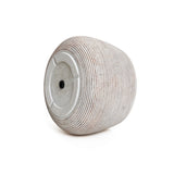 A round, ribbed, gray stone stool with a flat base and textured surface, embodying minimalist design elegance. Perfectly displayed against a white background.