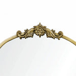 The LuxenHome Rêverie vintage gold accent mirror features an ornate metal frame with an antique finish, a floral design with swirling leaves, and an arched window silhouette. Its clear surface stands out beautifully against a plain white backdrop.