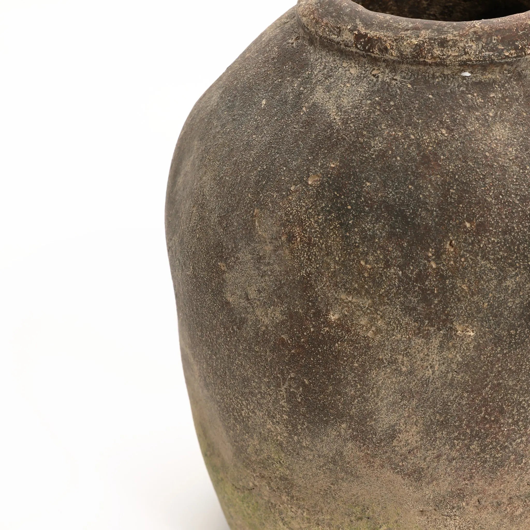 A close-up view of an aged, weathered ceramic pot with a handcrafted finish and muted color on a white background, embodying the rustic charm of a vintage terracotta vase.