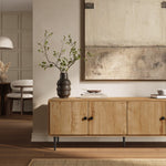 Wooden modern TV stand with doors, a dark vase with branches, books, and a tray on top.