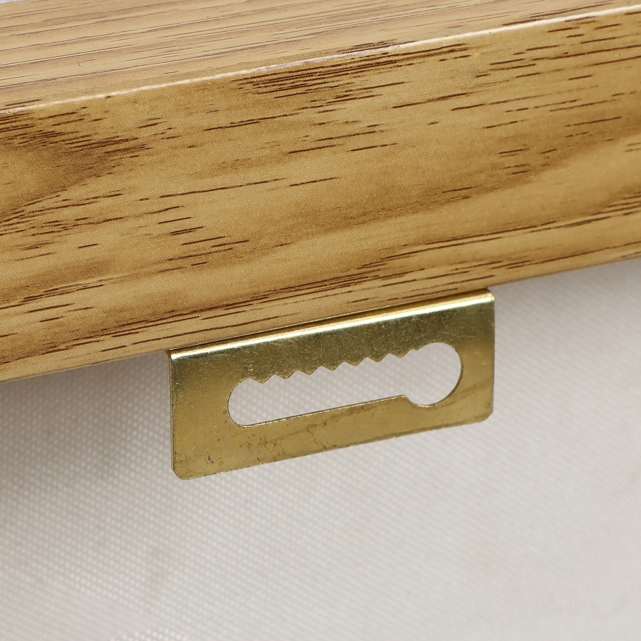 Close-up of a sawtooth picture hanger mounted on the back of a wooden frame, highlighting its role in supporting high-end art pieces as part of modern wall decor.
