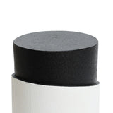 A cylindrical black object with a textured surface is partially inserted into a white sleeve featuring a unique white irregular pattern, set against a plain background.