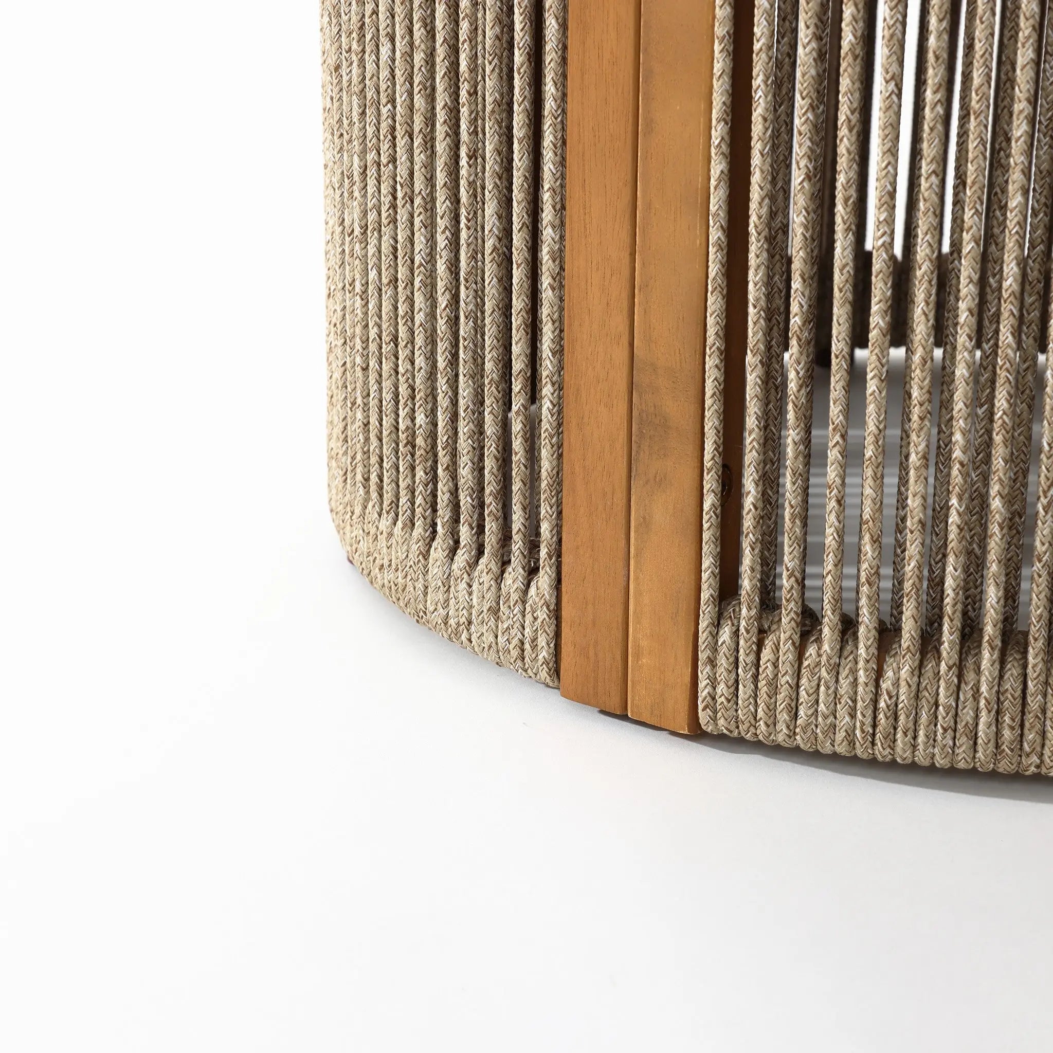 Close-up of a drum-shaped round end table featuring hand-woven rope and vertical slats, supported by a natural acacia wood beam on a white background.