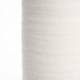 Close-up of a textured white surface, possibly resembling the delicate grain of a white terracotta vase, with soft lighting and subtle shadows enhancing its gentle contours.