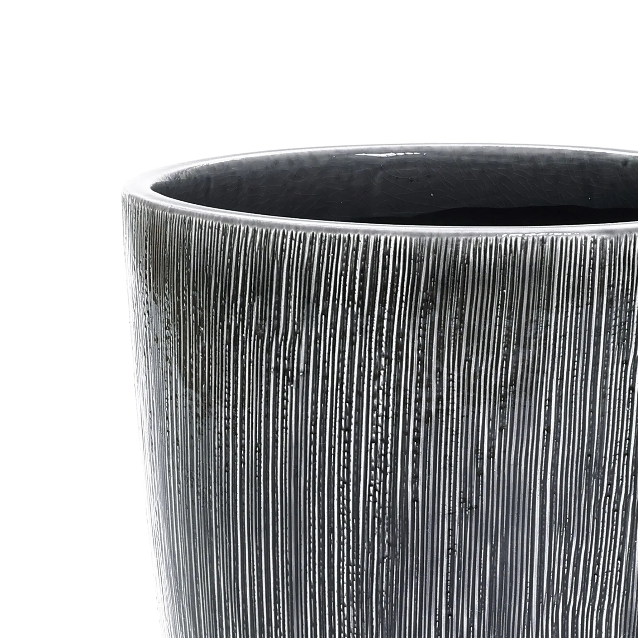 Close-up of the Sea gray ripples glazed tall ceramic planter by LuxenHome, 17 high, with vertical grooves and a shiny dark gray finish against a light gray background.
