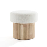 The LuxenHome Mina boucle and wood storage ottoman features a textured white cushioned seat with a cylindrical base of vertical wooden slats. Its modern, minimalist design blends neutral colors and natural materials, adding elegance to any space.