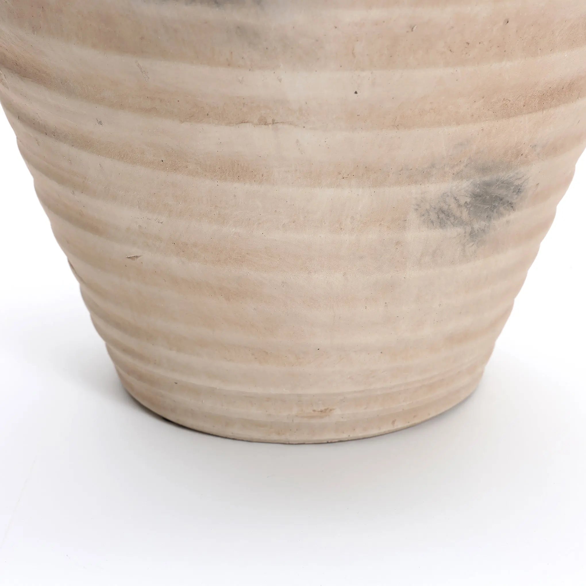 A LuxenHome Rustic beige ribbed terracotta urn vase, measuring 13.2 in height, sits on a white surface. Its handcrafted details and slight discolorations add rustic charm akin to a terracotta vase.