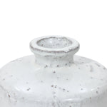 Close-up of a stoneware vase with a smooth white glaze and small dark speckles, featuring a bottle-like design with a narrow neck and rounded rim.