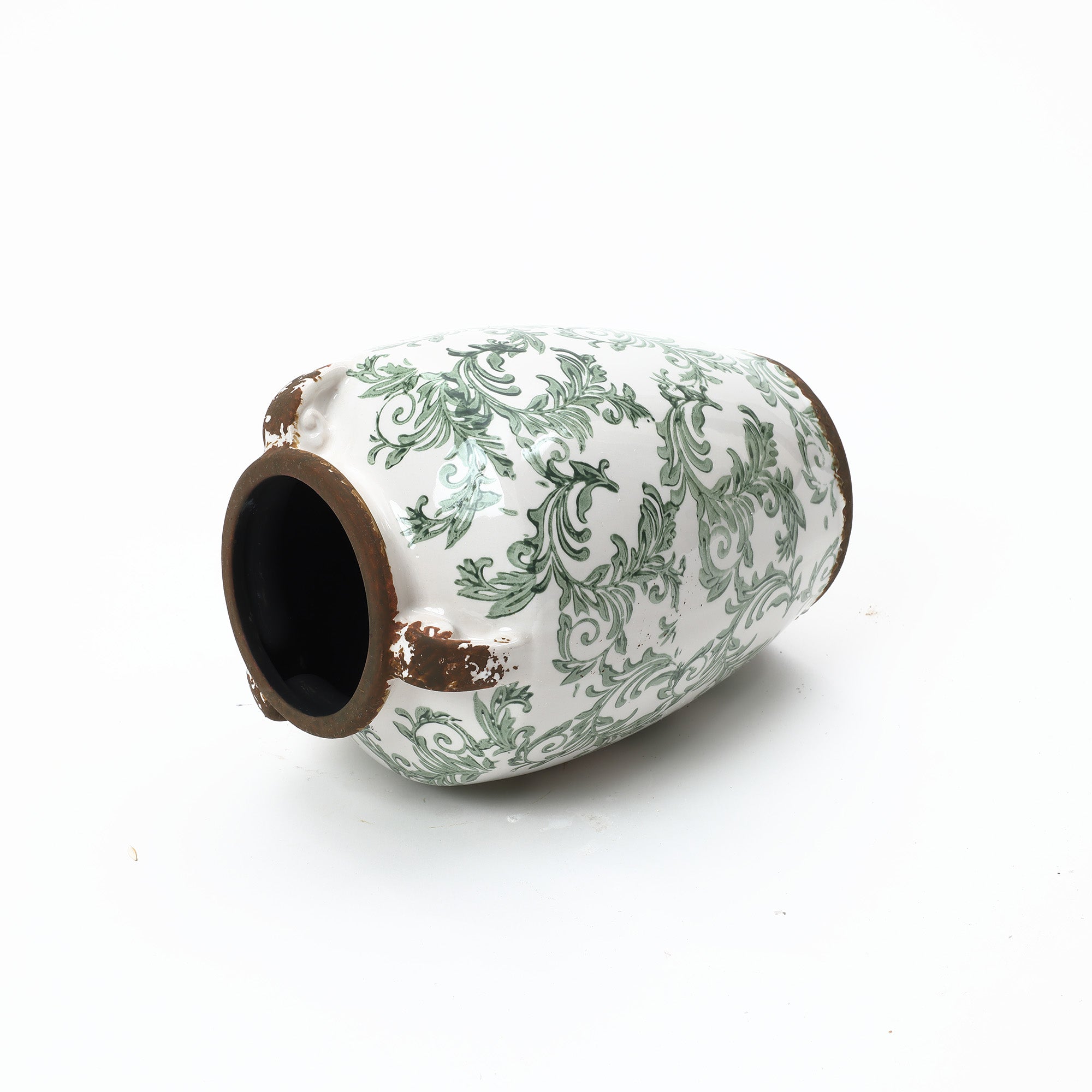 Round floral ceramic vase with green patterns and worn edges, showcasing artisanal craftsmanship.