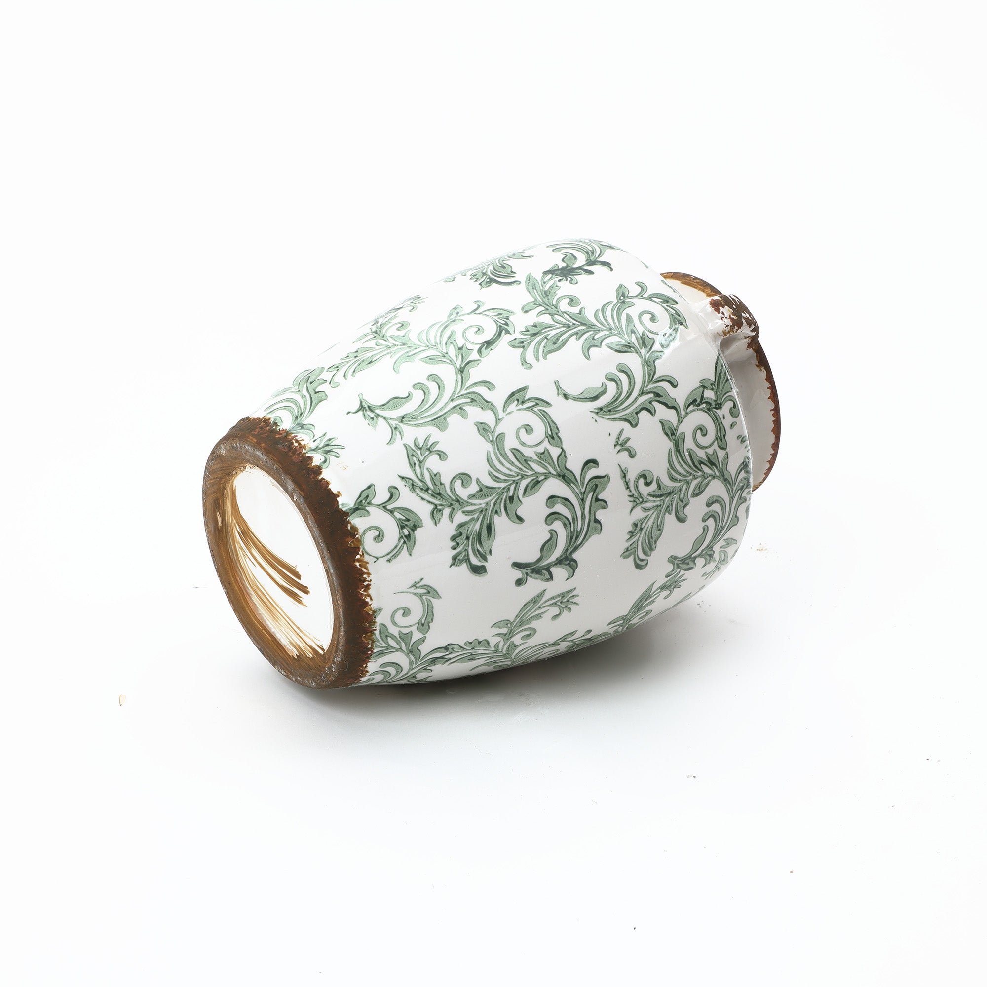 Round floral ceramic vase with worn, brown-edged rims lies on its side against a white background.