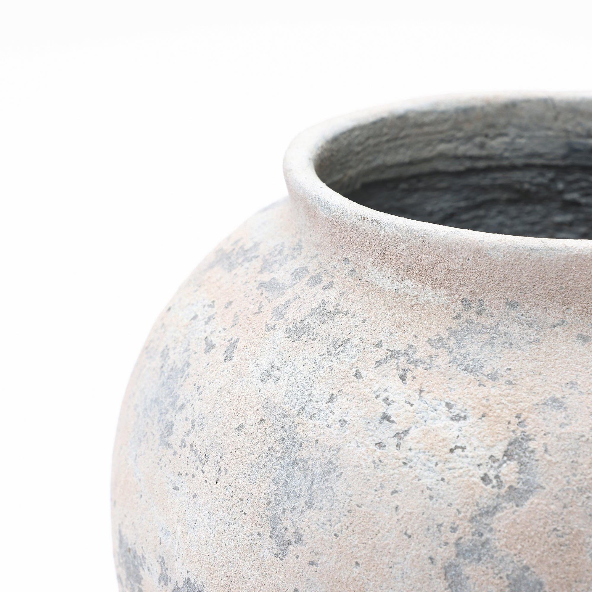 Close-up of the upper part of a wide opening, showing a textured, weathered surface in neutral tones against.