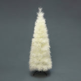 White artificial christmas tree with fluffy, feather-like branches stands on  black metal stand against plain gray background.