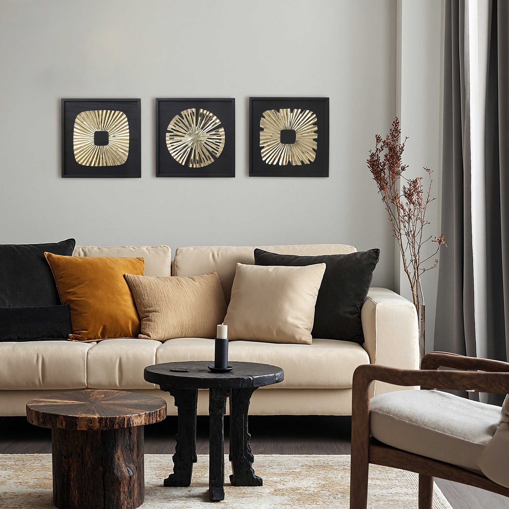 Beige sofa featuring three abstract metal wall art pieces above and two wooden tables in the foreground.