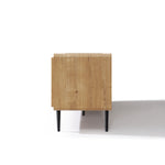 Side view of a wood TV stand with black legs, placed on a white surface with a shadow cast to the right.