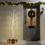 Pre-lit christmas tree glows beside wrapped presents, wreath on the door, garland with lights.