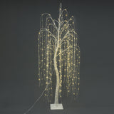 Artificial willow tree with white branches ,cascading led fairy lights stands on rectangular white base against dark background.