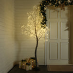 Decor led tree stands near wrapped presents white door, garland hanging above, in a warmly lit room with paneled walls.