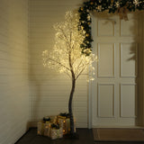 Decor led tree stands near wrapped presents white door, garland hanging above, in a warmly lit room with paneled walls.