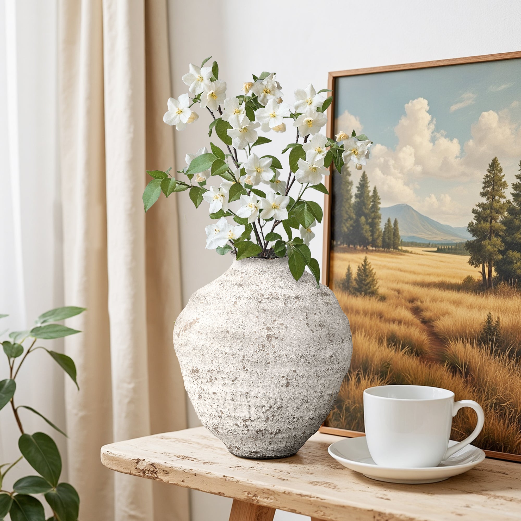 Textured cement vase with white flowers sits on a wooden table beside, creating a calming home décor scene.