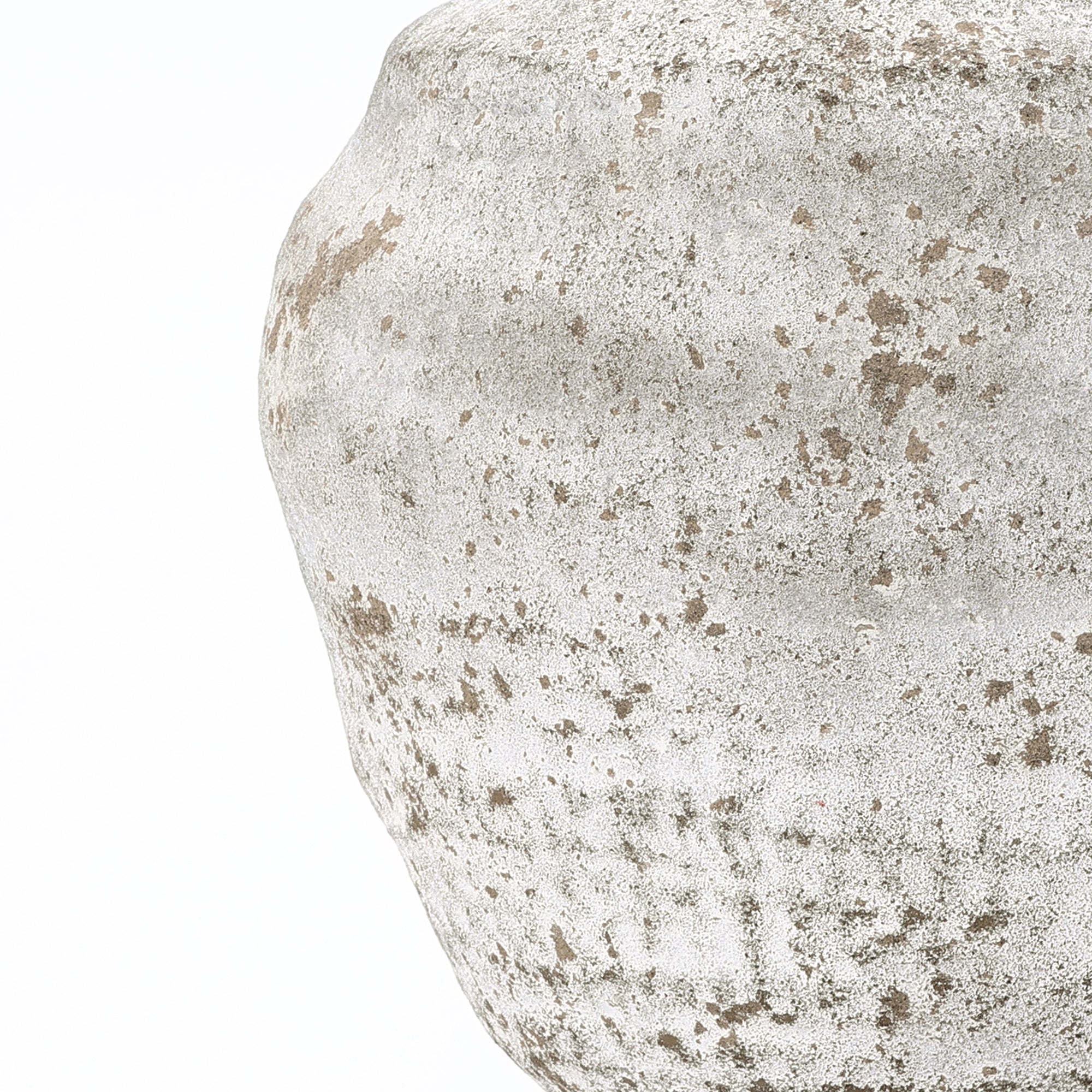 Close-up of a cement vase with a weathered speckled surface, adding modern flair to your home décor.