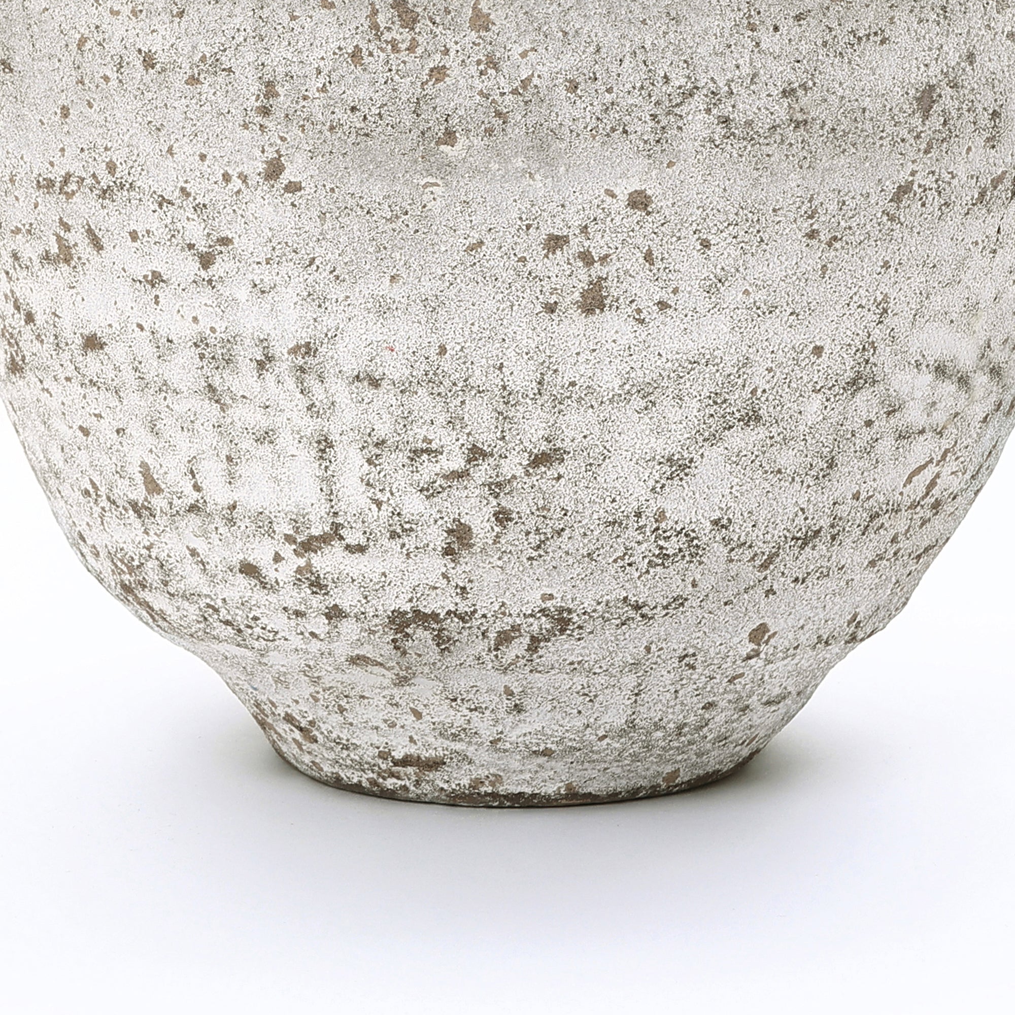 Close-up of the lower portion of a textured cement vase, showcasing its rough, speckled surface.