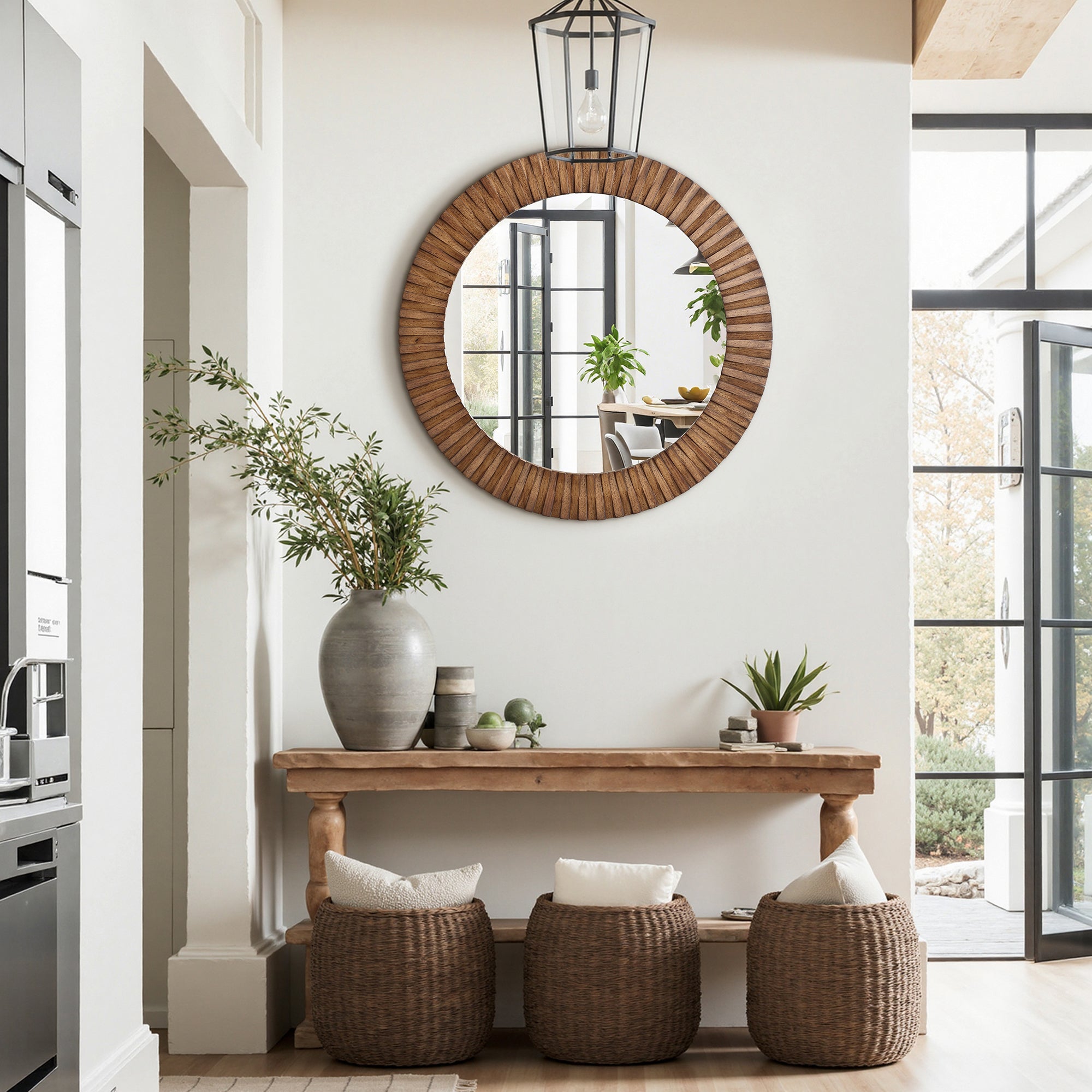 Sits below a round wall mirror with an oak wood frame on a white wall in a bright, modern entryway.