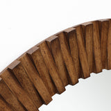 Close-up of a round wall mirror with a thick, ridged oak wood frame featuring a striking diagonal pattern.