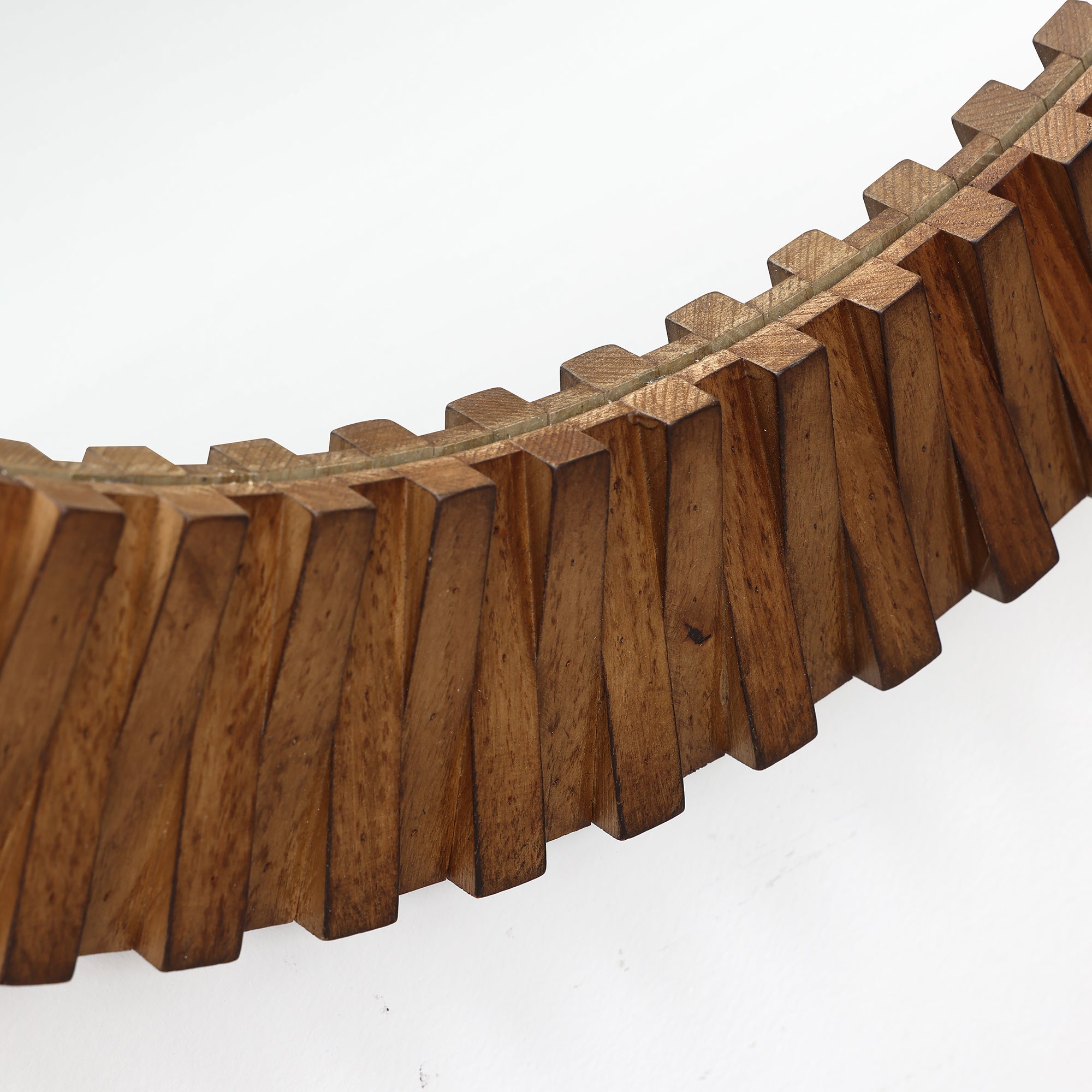 Close-up of an oak wood frame with angled, geometric segments, photographed against a plain.