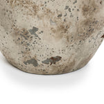 Close-up of the bottom edge of a Terracotta Vase with a weathered beige finish and gray-brown speckled texture, showing rustic farmhouse character against a white background.