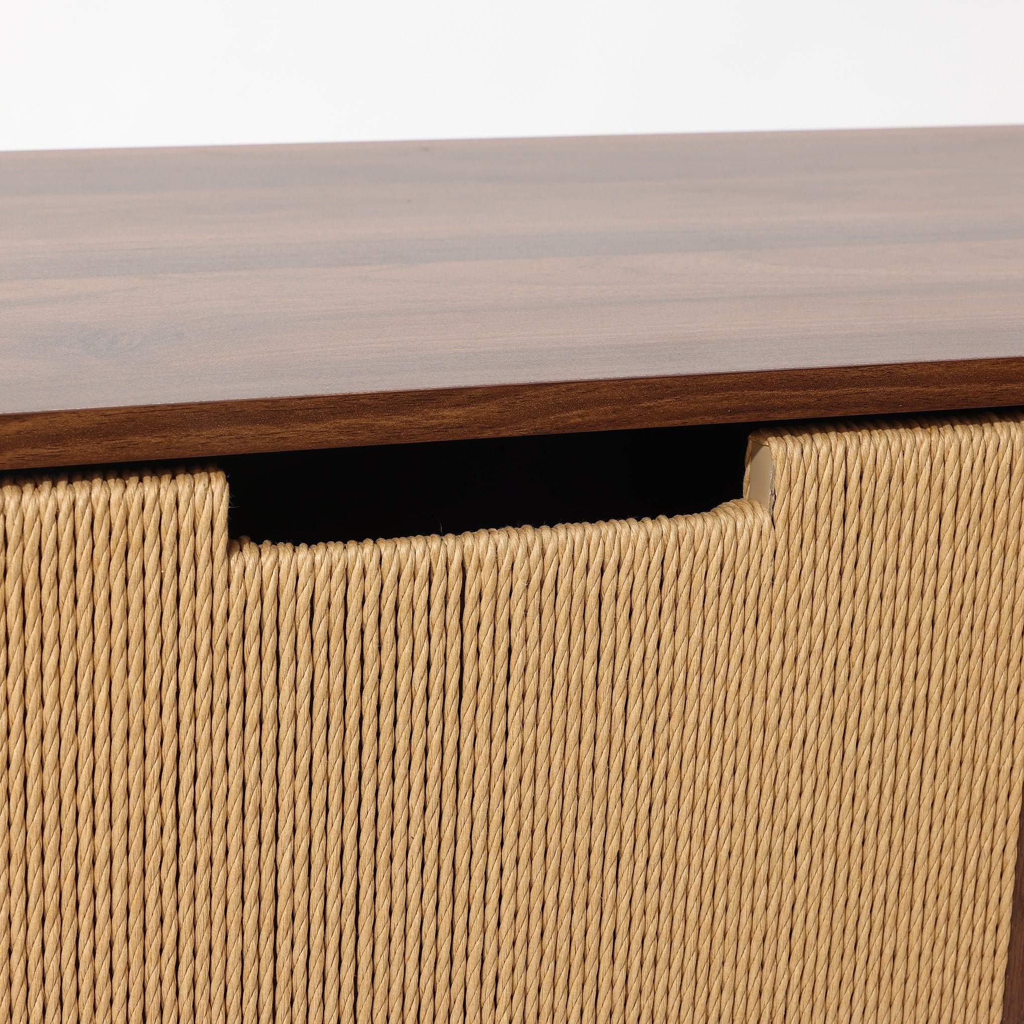 A close-up of wood storage cabinet solution with a wooden top and woven rope front, featuring a cut-out handle for easy opening.