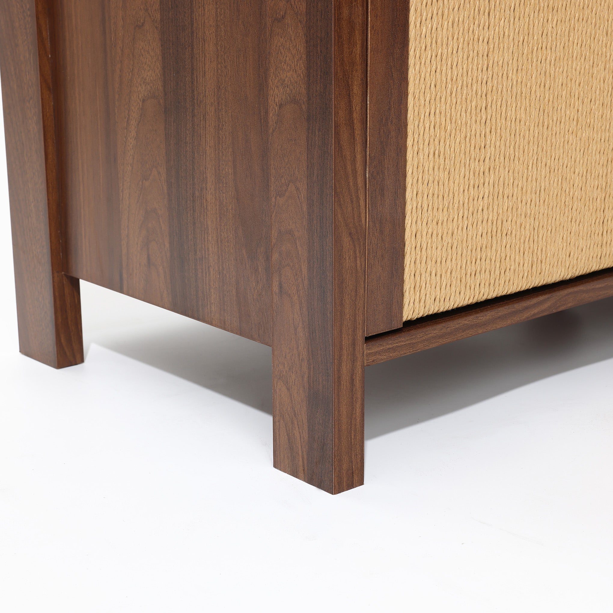 Close-up of the bottom corner of a wood storage cabinet with vertical legs and a textured beige side panel.
