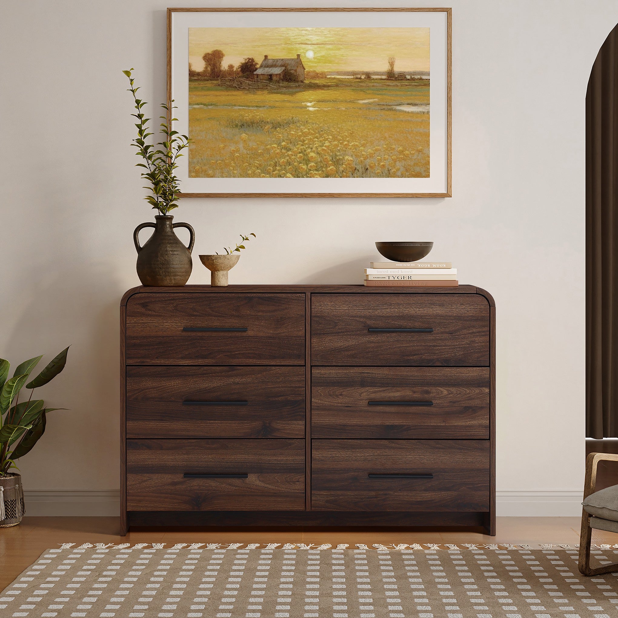 A walnut dresser with six drawers decor with vases, bowls, and books.