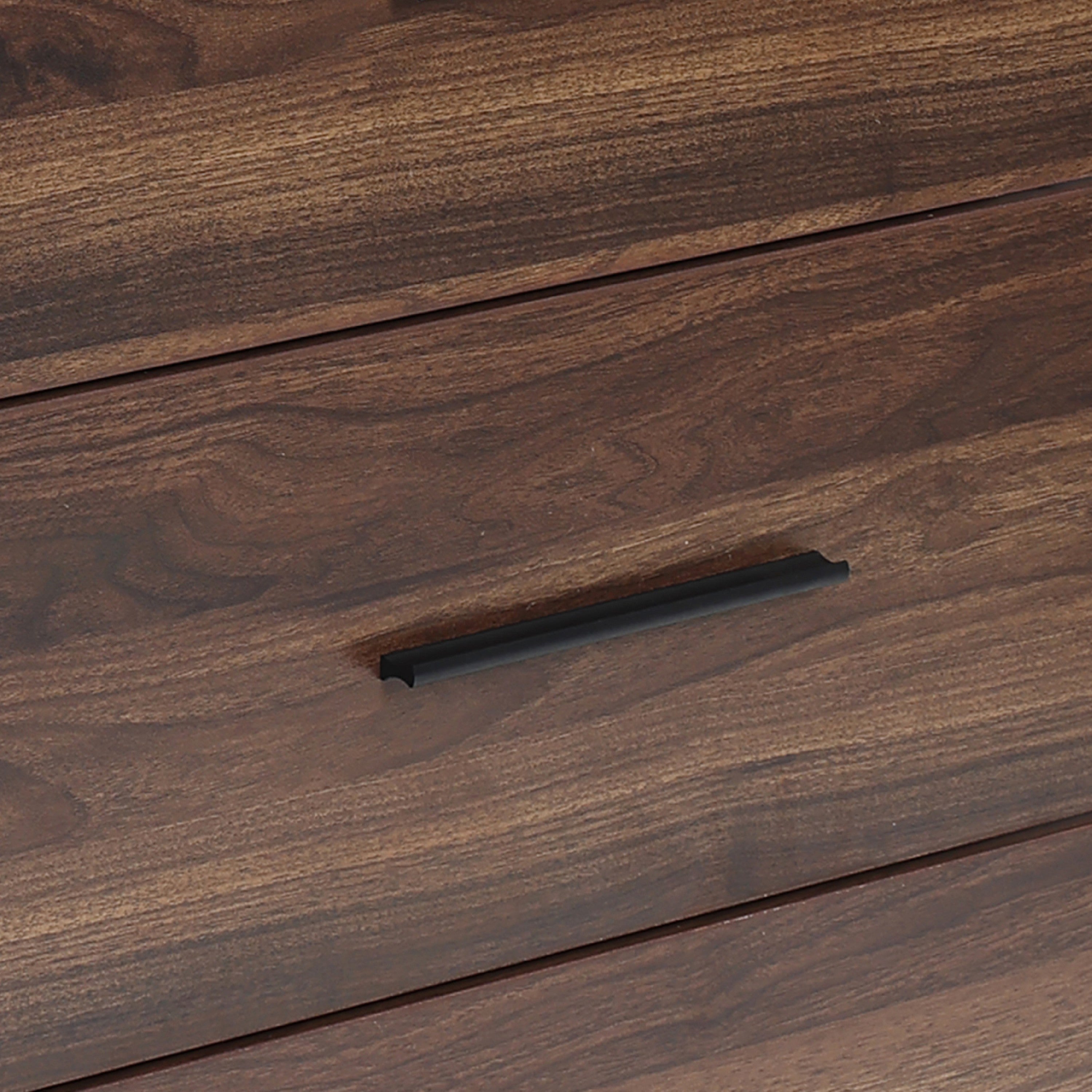 A close-up of a wood storage chest drawer with a dark, horizontal metal handle.