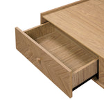 The drawer is part of a light oak Japandi coffee tablewith a flat top surface, revealing an empty interior.