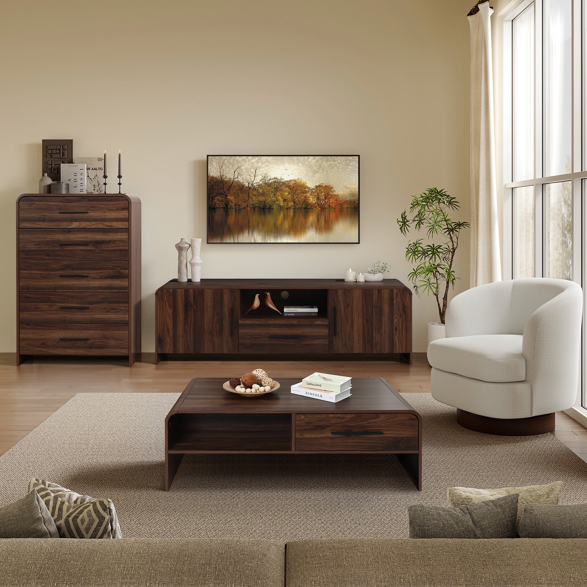A wooden coffee table wtih decor items, framed landscape art on the wall.