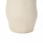 Close-up of a smooth, ivory white ceramic vase serving as a striking accent piece against a white background.