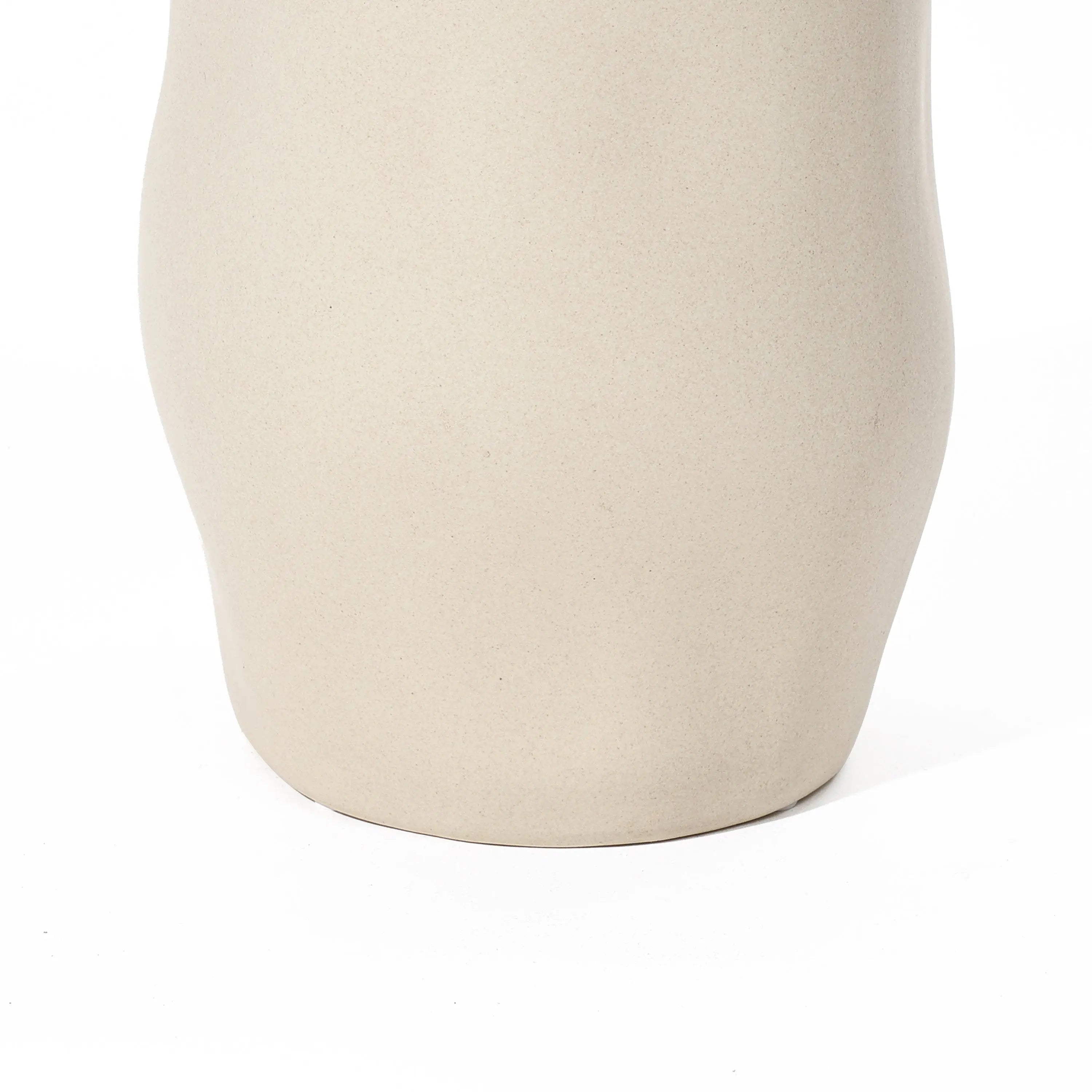 Close-up of a smooth, ivory white ceramic vase serving as a striking accent piece against a white background.