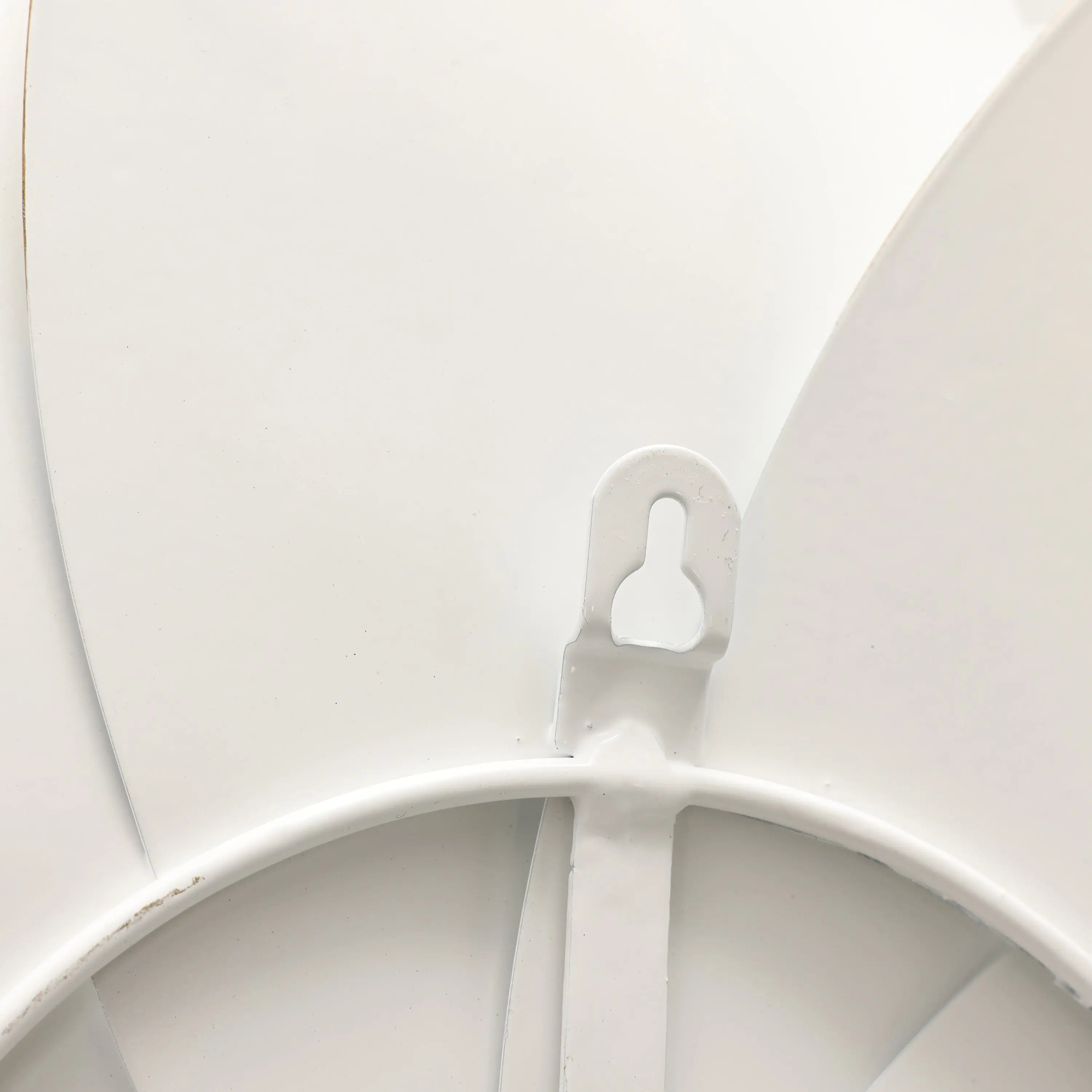 Close-up of a white ceiling fan blade attachment, showcasing a metallic art-inspired hook-like connector.