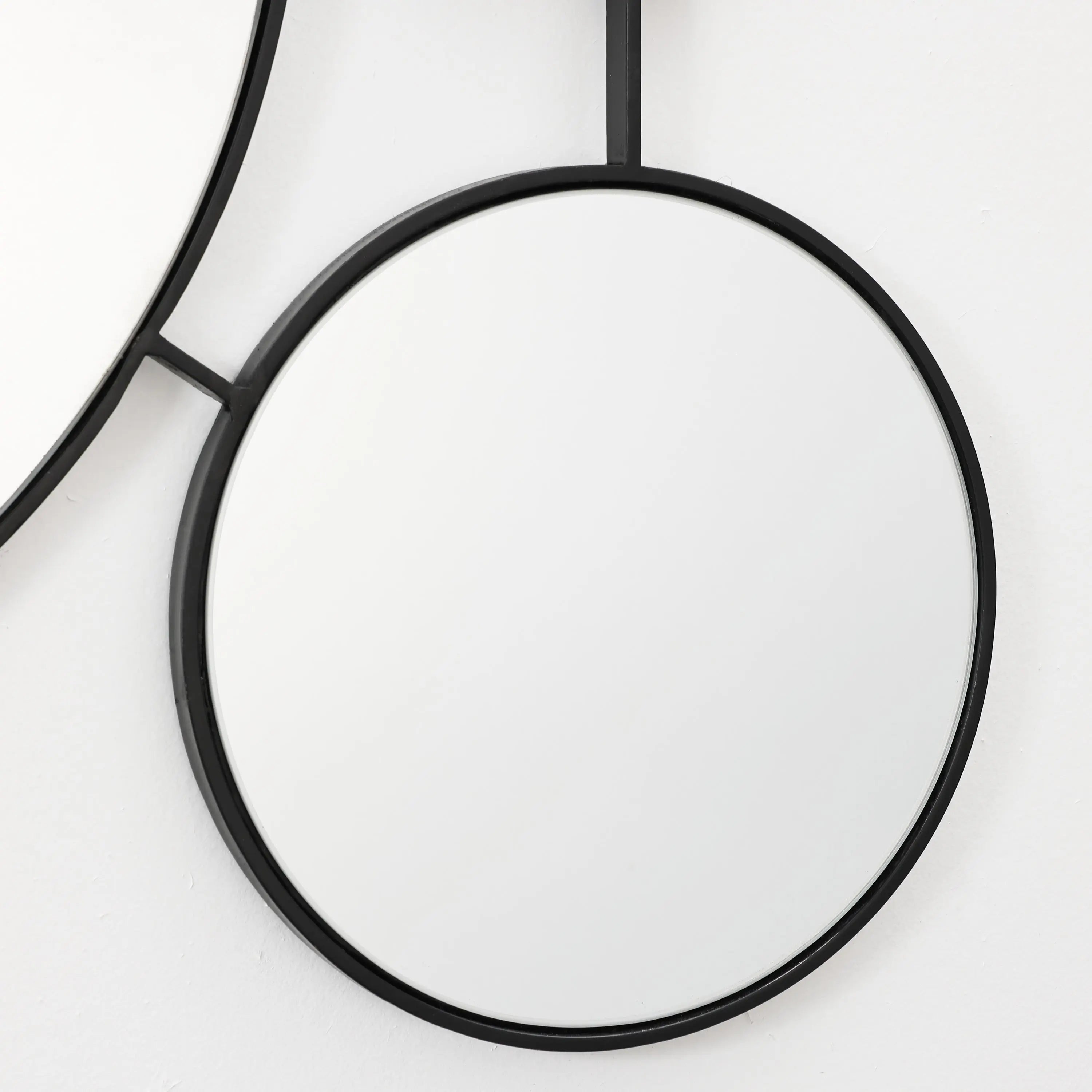 black-circular-mirror-and-black-rope-on-a-white-background